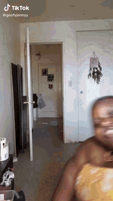 a person is standing in a room with a door open and a sign that says tik tok on it