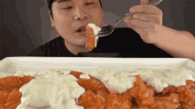 a man is eating food with a fork from a plate