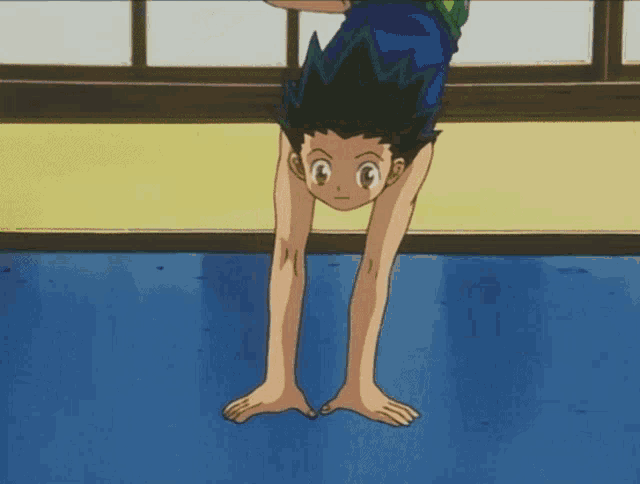 a boy in a blue tank top is laying on the floor