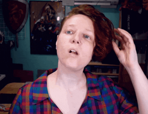 a woman wearing a plaid shirt holds her hair in front of a sign that says free web