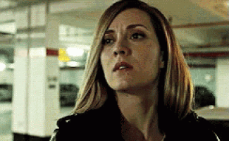 a close up of a woman 's face in a parking garage looking at the camera .