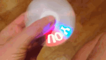 a person is holding a glow in the dark object with the word nook written on it