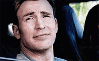 a man is sitting in the back seat of a car with his eyes closed .