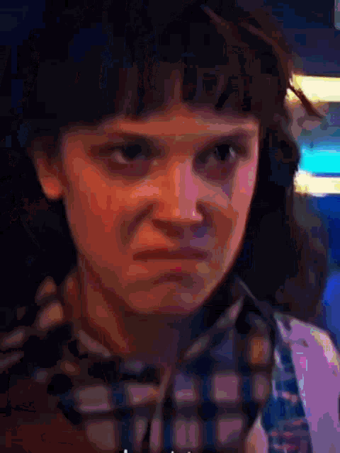 a close up of a woman 's face with a serious look on her face .