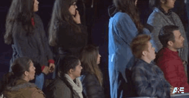 a group of people are sitting in a row watching a show .