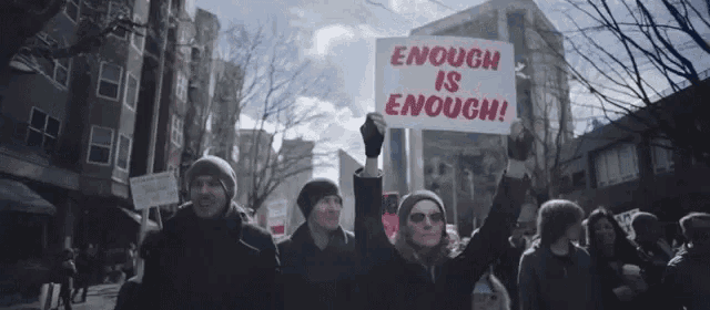 a protester holds up a sign that says enough is enough