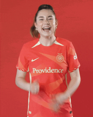 a woman wearing a red providence shirt is laughing