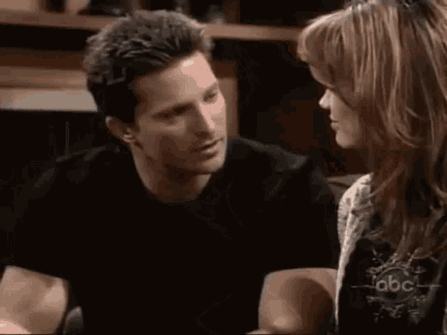a man and a woman are looking at each other .