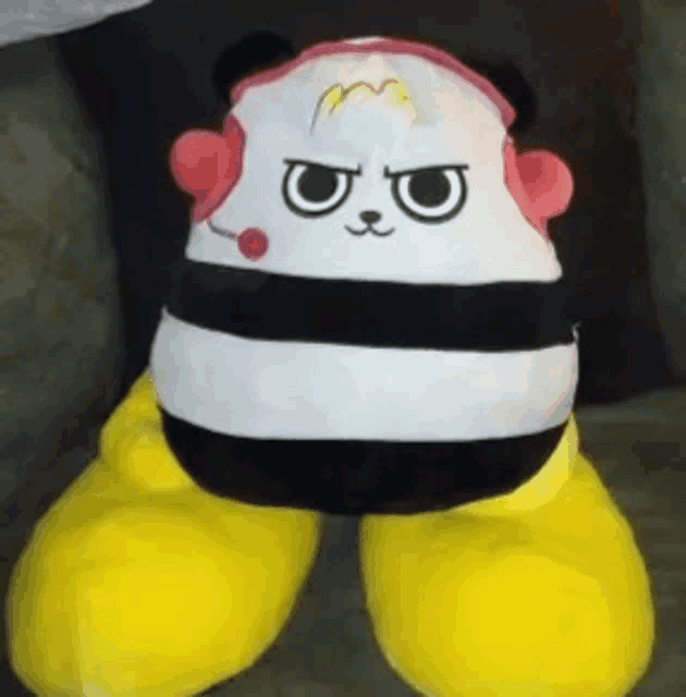 a black and white stuffed animal with yellow legs and a microphone on it .
