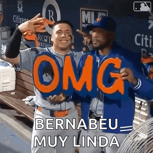 two baseball players holding up a sign that says " omg "