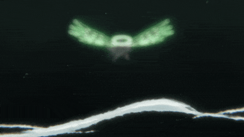 a person 's hand is holding a white string in front of a green light