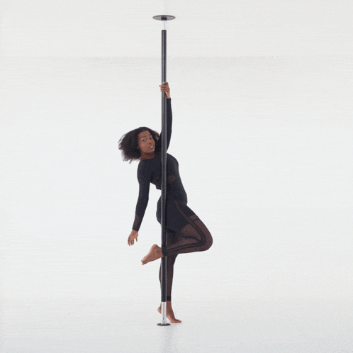 a woman is standing on a pole with her arms outstretched