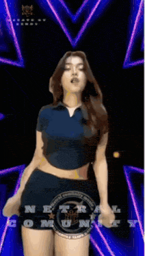 a woman in a crop top and shorts is dancing in front of a sign that says netr community music