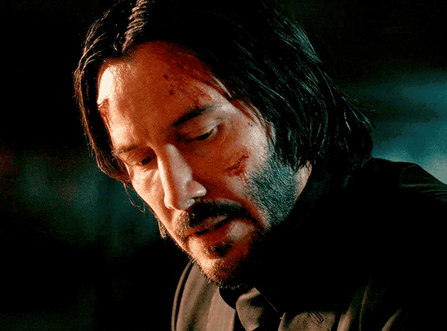 a man with a beard and long hair has blood on his face