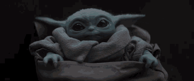 a baby yoda toy is sitting in a bag
