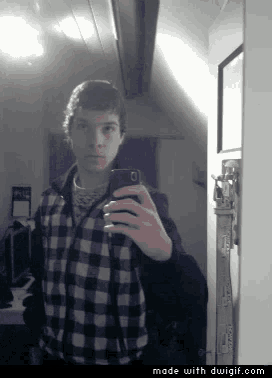 a young man is taking a selfie in front of a mirror with the words made with duigif.com below him