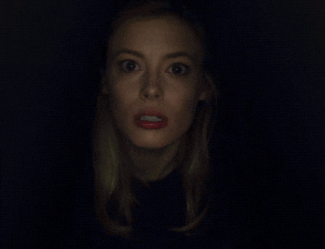 a close up of a woman 's face with a surprised expression
