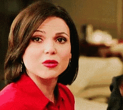 a woman in a red shirt is making a funny face and looking at the camera .