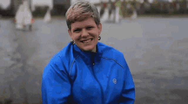 a woman wearing a blue jacket with a logo on it