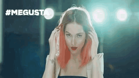 a woman with red hair is standing in front of a sign that says #megusta