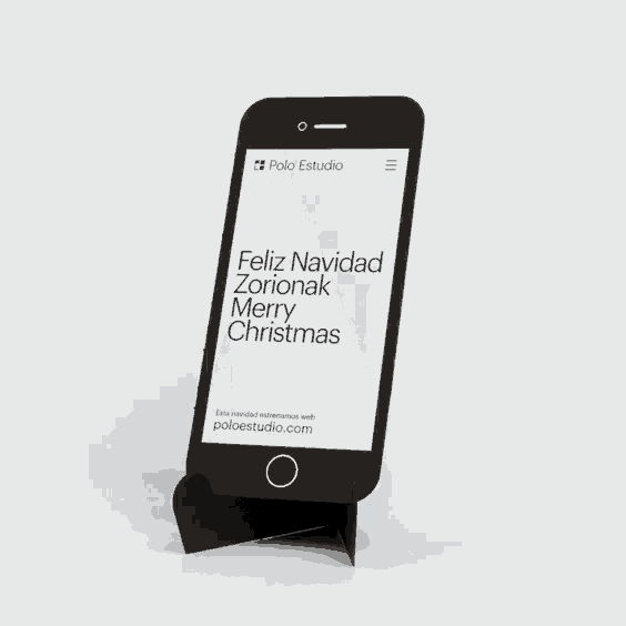 a black cell phone is displayed on a cardboard holder
