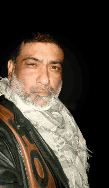 a man wearing a scarf and a leather jacket with the letter o on the back