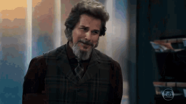 a man with a beard wearing a plaid vest