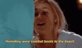 a woman is standing in front of a blue curtain with the words `` homeboy were combat boots to the beach '' written on it .