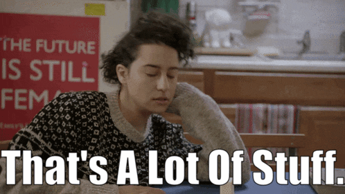 a woman sits at a table with the words that 's a lot of stuff written below her