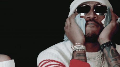 a man wearing sunglasses and a beanie is holding a bunch of money