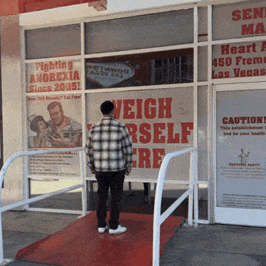 a man is standing in front of a sign that says weigh yourself