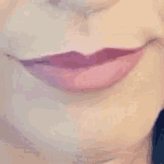 a close up of a woman 's lips with purple lipstick sticking out her tongue .