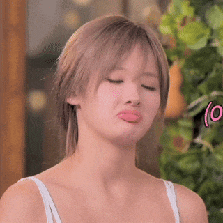 a woman in a white tank top is making a funny face with her tongue out .