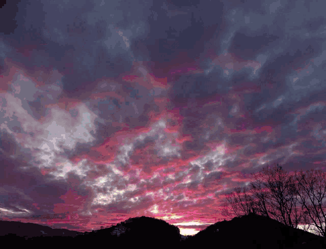 a picture of a sunset with the words o noc written in neon