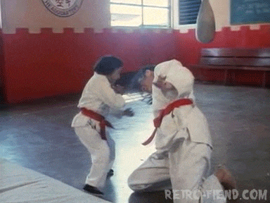 a man and a girl are practicing martial arts in a gym with retrofriend.com written on the bottom right