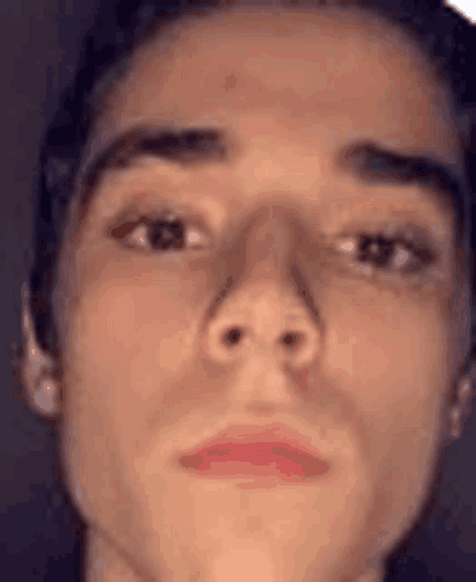 a close up of a young man 's face with a red lip and eyebrows .