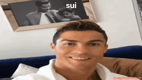 a man sitting on a couch with a picture behind him that says " sui "