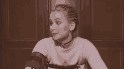 a woman is sitting at a table and says `` told you '' while wearing a choker .
