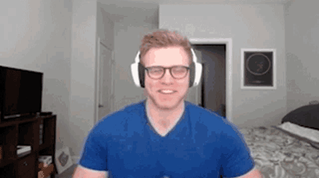 a man wearing glasses and headphones is standing in a room .