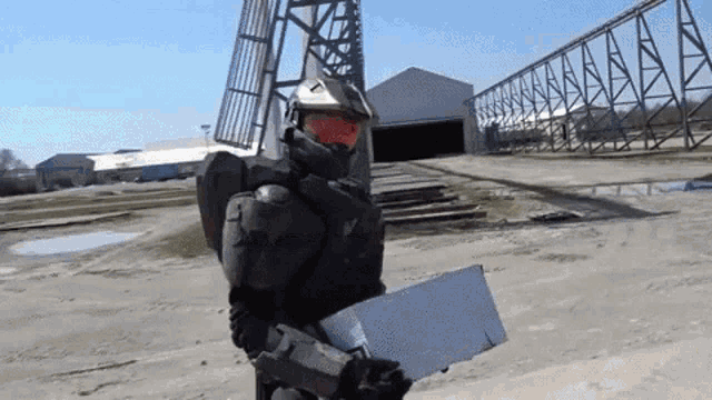 a man in a military uniform is holding a box in front of a building