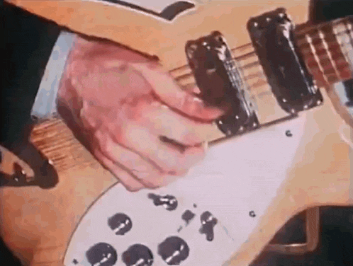 a man in a suit is playing a guitar with his fingers .