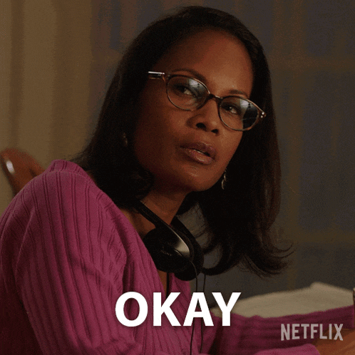a woman wearing glasses and headphones has the word okay above her head