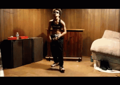a man is dancing in a room with a couch