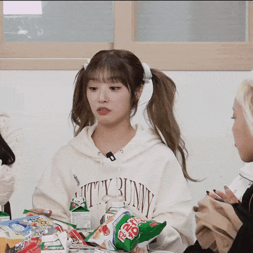 a girl wearing a white hoodie that says kitty bunny on it