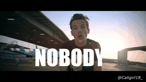 a man is standing in front of a plane with the word nobody written on the bottom