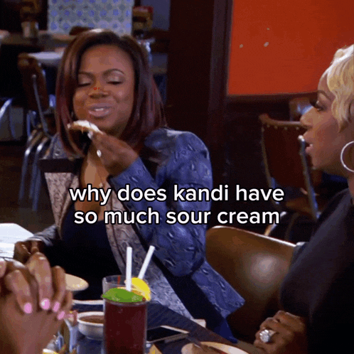 two women are sitting at a table with a caption that says why does kandi have so much sour cream