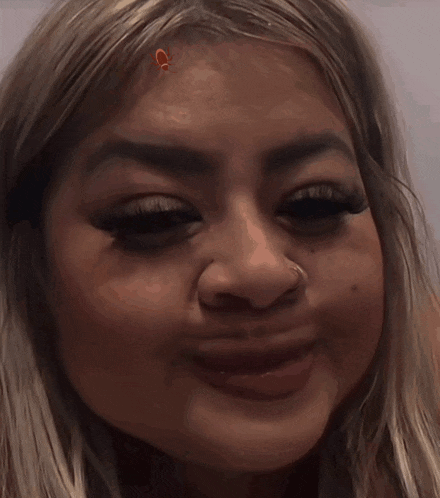 a close up of a woman 's face with a nose piercing