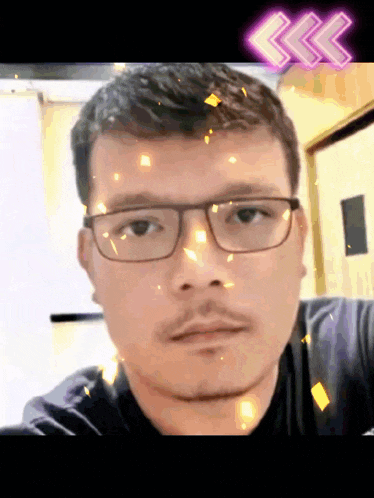 a man wearing glasses looks at the camera with arrows pointing to the right