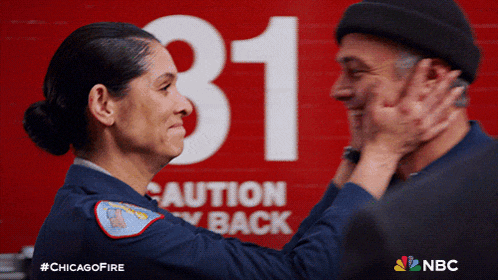 a man and a woman are hugging in front of a sign that says caution stay back