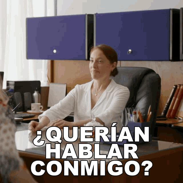 a woman sits at a desk with the words " querian hablar conmigo " written on it